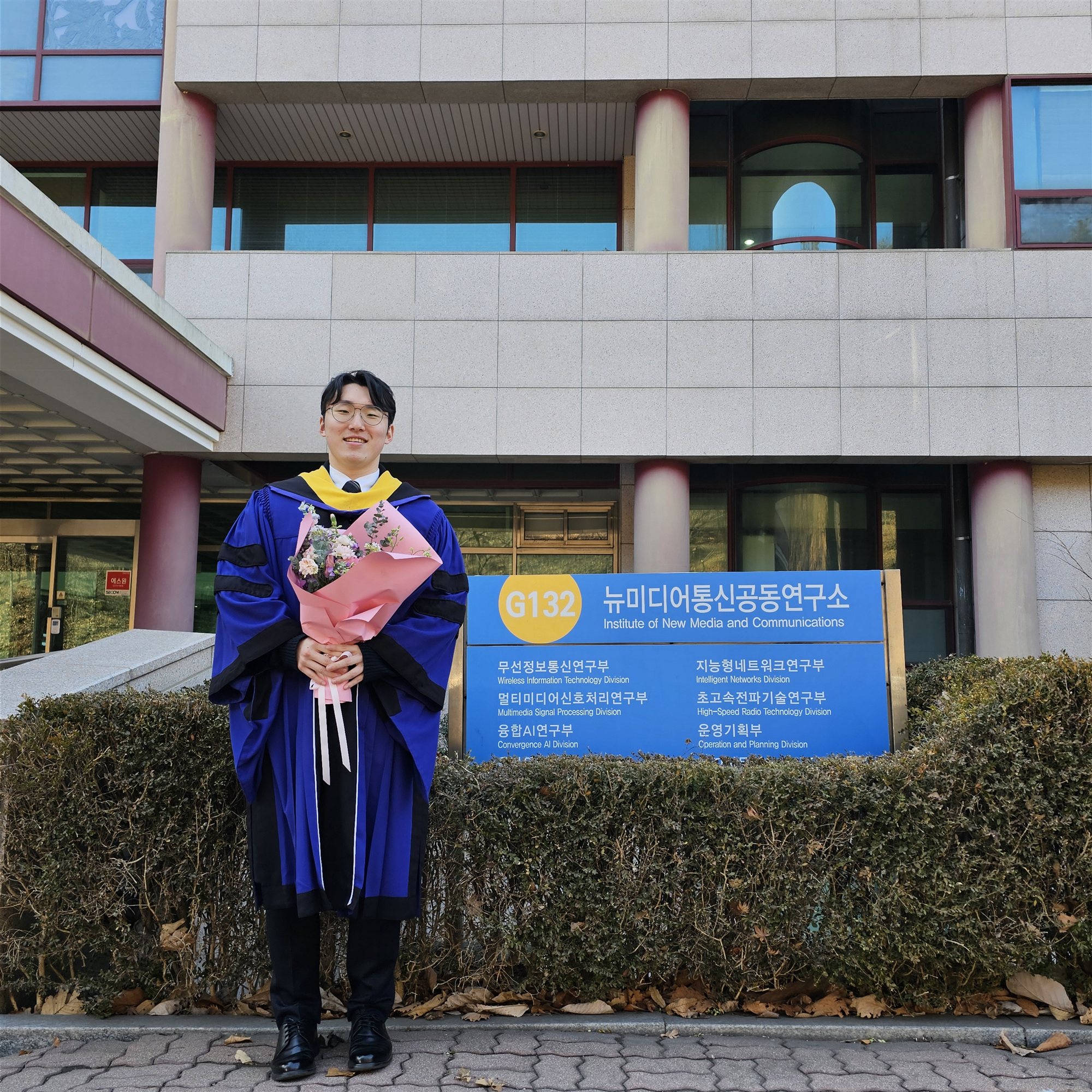 Graduation portrait outside the Institute of New Media and Communications